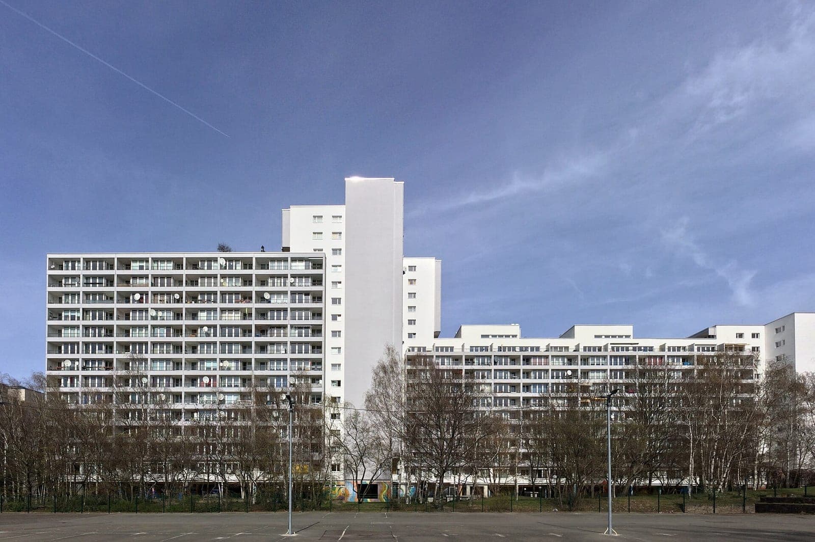 مبانٍ سكنية بيضاء عالية عند ساحة Mehringplatz في حي Kreuzberg في برلين.