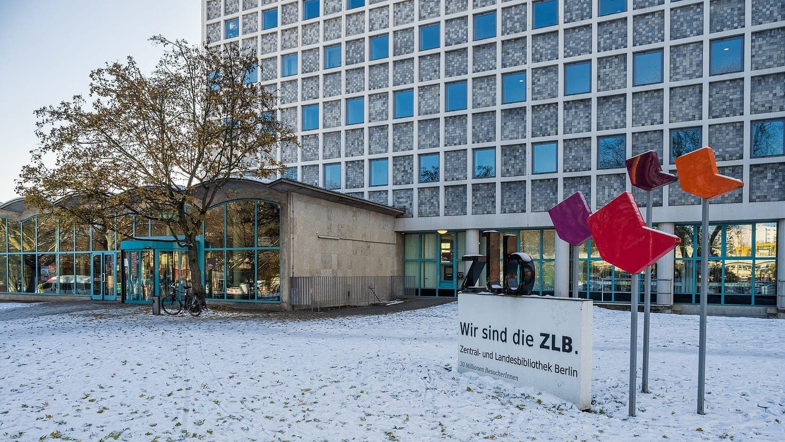 لوحة أمام مبنى المكتبة المركزية والولائية في برلين كُتب عليها بالألمانية "Wir sind die ZLB"، والأرض مغطاة بالثلج